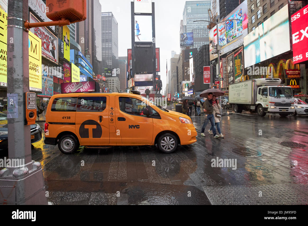 Nissan nv200 New York gelbes Taxi Cab überqueren Times Square in New York City USA Regen Stockfoto