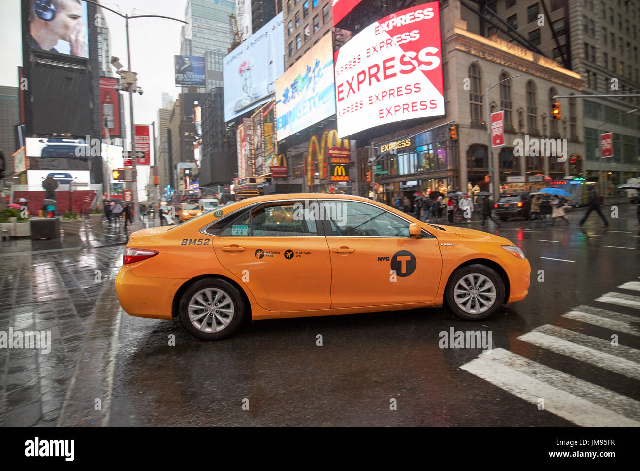 Toyota Camry Hybrid New York gelbes Taxi Cab überqueren Times Square in New York City USA Regen Stockfoto