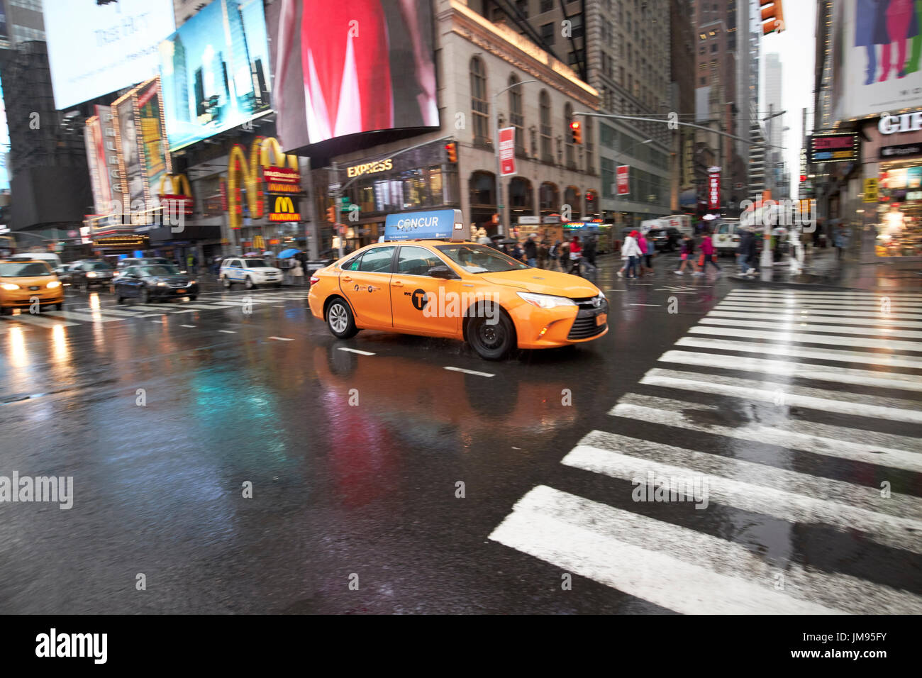 Toyota Camry Hybrid New York gelbes Taxi Cab überqueren Times Square in New York City USA Regen Stockfoto