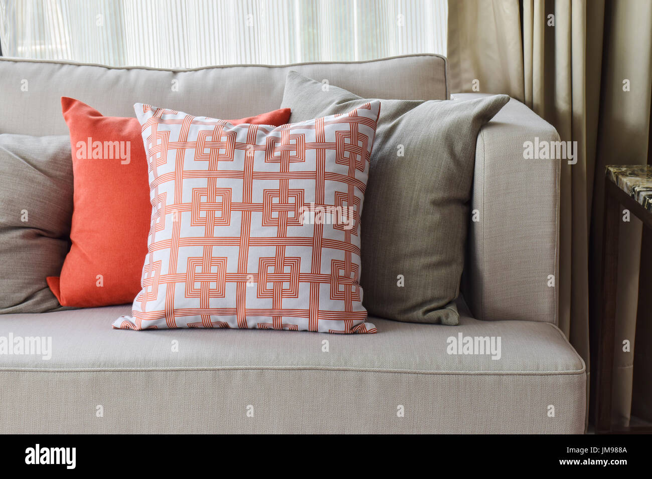 Chinesische Muster in orange und tief orange und grau Kissen auf leichten  grauen Sofa-set Stockfotografie - Alamy