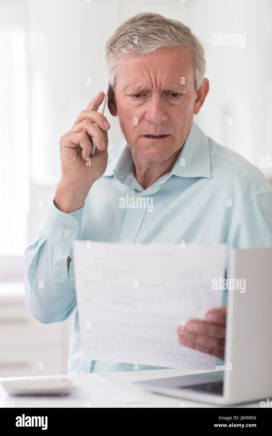 Unglücklich Senior Mann am Telefon Abfragen von Bill Stockfoto