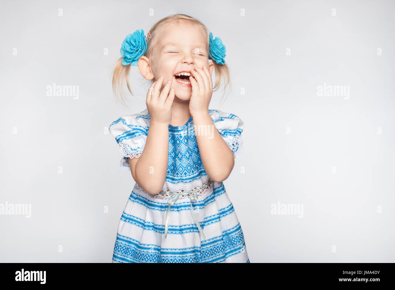 Niedliche kleine Mädchen Lachen auf einem weißen Hintergrund Stockfoto