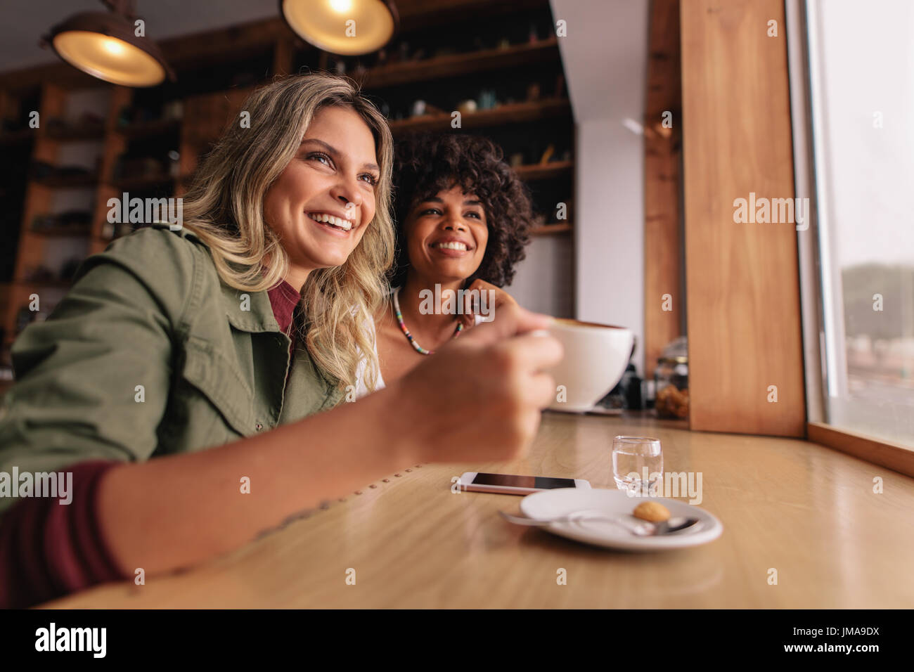 Zwei junge Frau im Café sitzen und Kaffee trinken. Freundinnen trinken Kaffee im Restaurant. Stockfoto