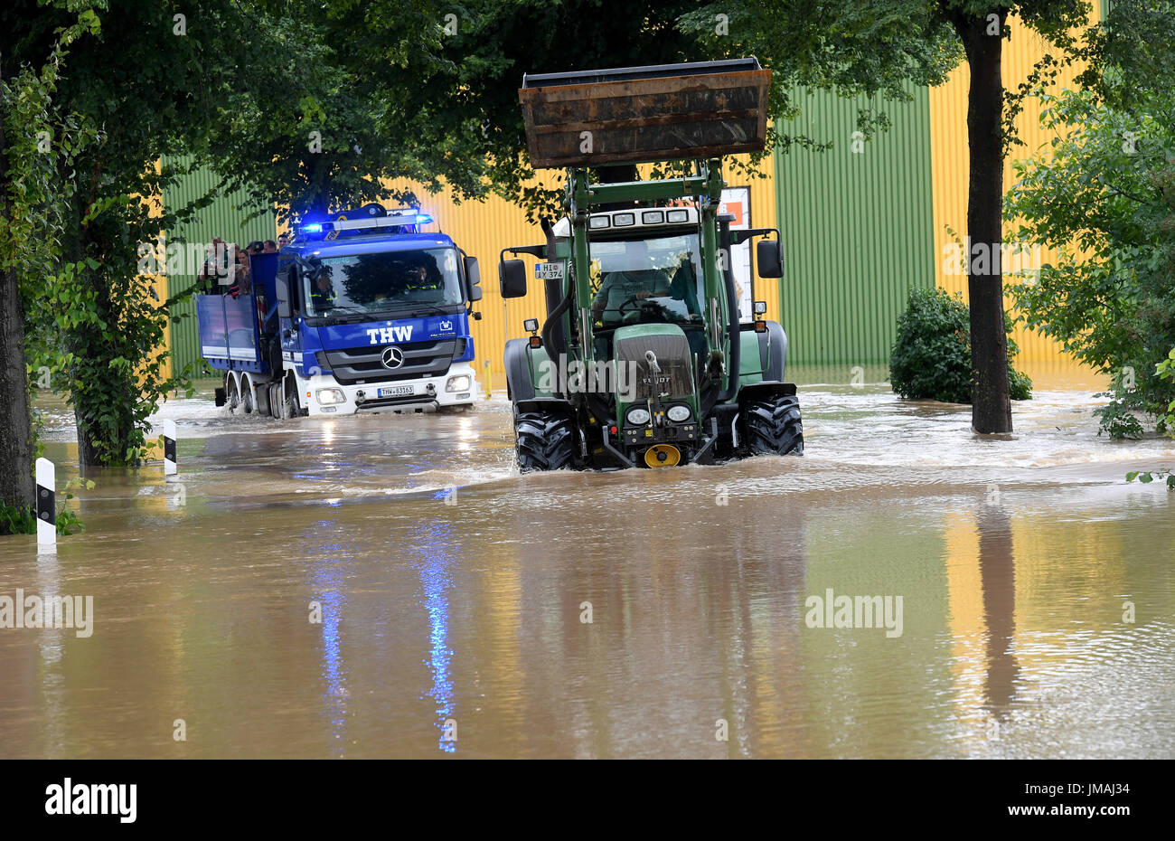 Klein Duengen, Deutschland. 26. Juli 2017. Ein Traktor und ein Fahrzeug der Bundesanstalt Technisches Hilfswerk Holding evakuiert Menschen Antriebe durch das Hochwasser des Flusses Innerste am Rande der Stadt von Klein Duengen, Deutschland, 26. Juli 2017. Nach kontinuierlicher sind Regenfälle Teile der Süden von Niedersachsen überflutet. Foto: Holger Hollemann/Dpa/Alamy Live News Stockfoto