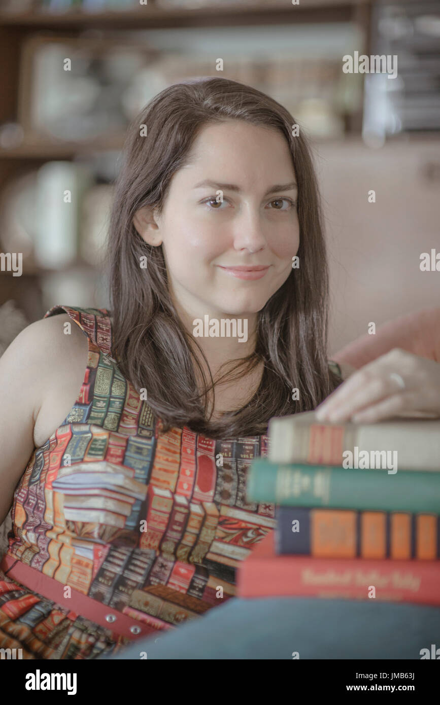 Frau mit Büchern in einem Kleid mit Büchern über es Stockfoto