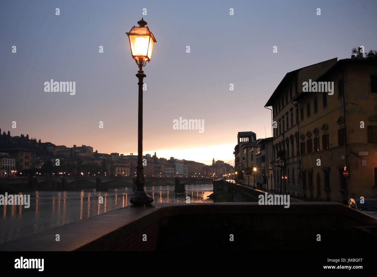 Nacht in Florenz. Glühende Vintage Straßenlaterne auf Hintergrund mit Fluss Arno Stockfoto