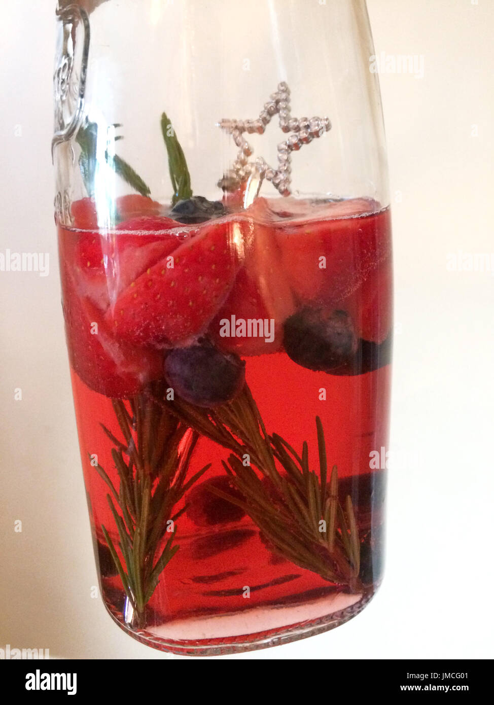 Krug mit Sommer-cocktail mit Erdbeeren, Rosmarin und Heidelbeeren Stockfoto