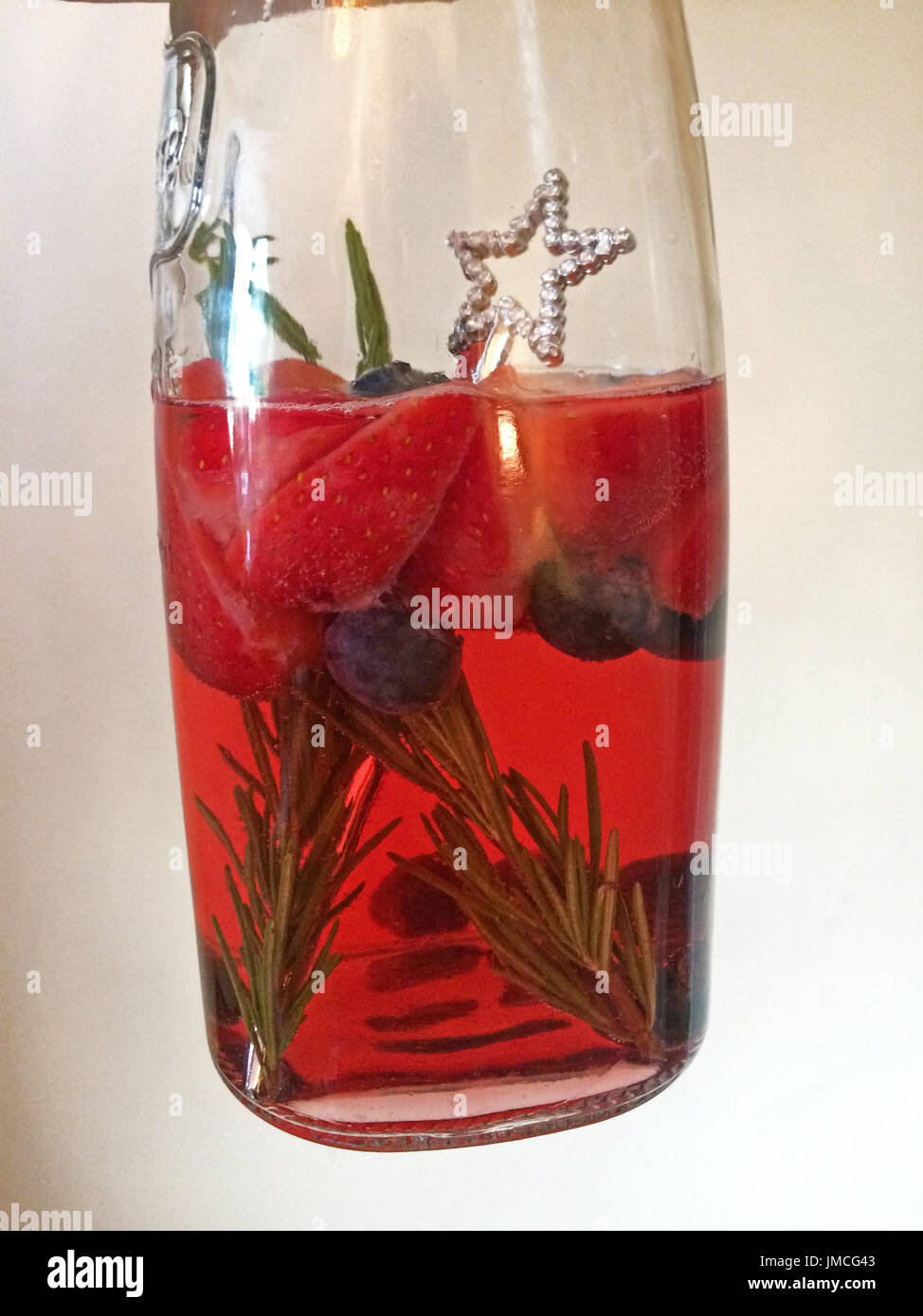 Krug mit Sommer-cocktail mit Erdbeeren, Rosmarin und Heidelbeeren Stockfoto