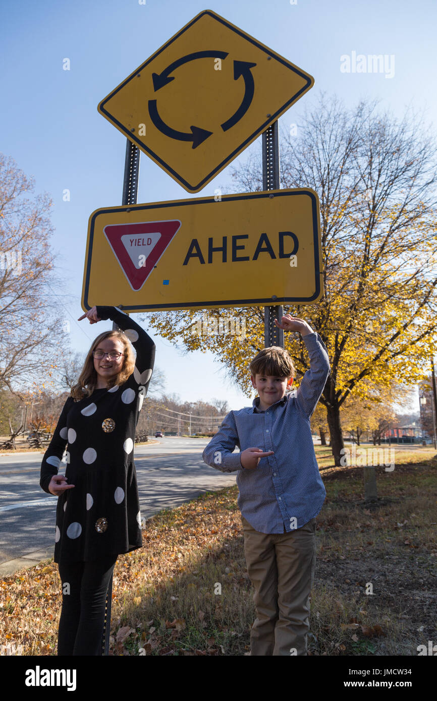 Zwei Kinder am Kreisverkehr-Schild Stockfoto