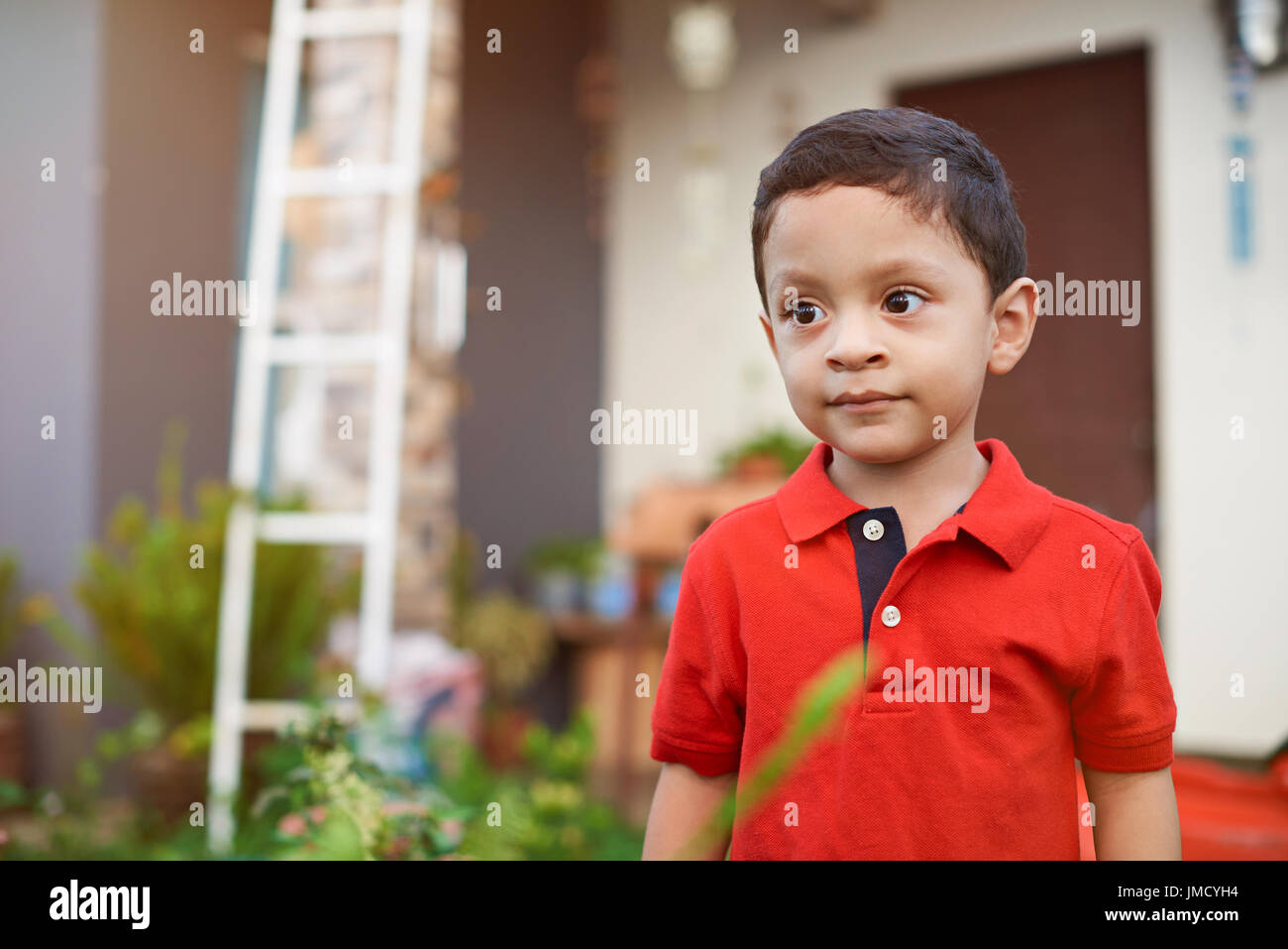 Neugierig Latino Jungen Geißlein auf Hausgarten Stockfoto