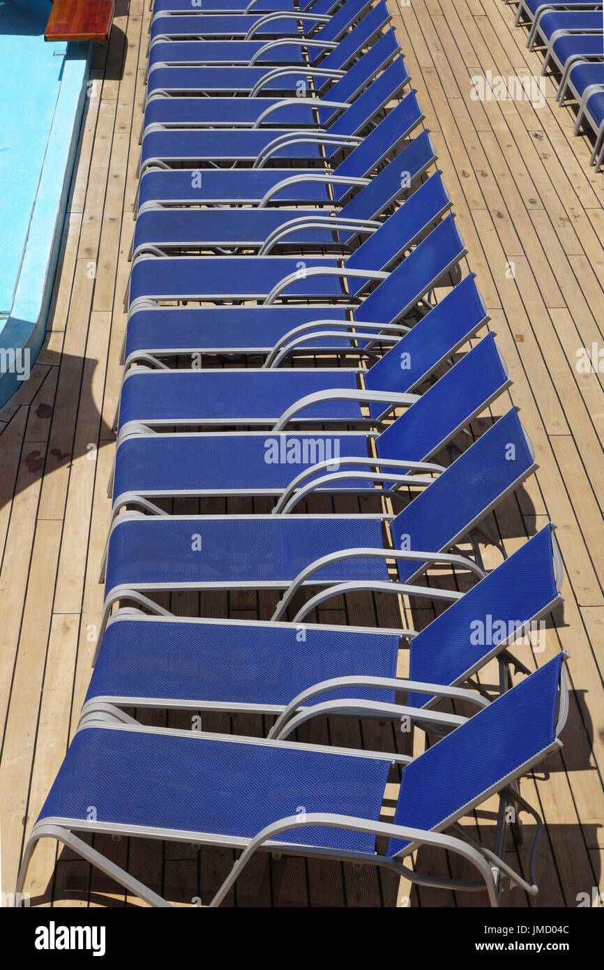 Liegestühle am Pool auf einem Kreuzfahrtschiff aufgereiht Stockfoto