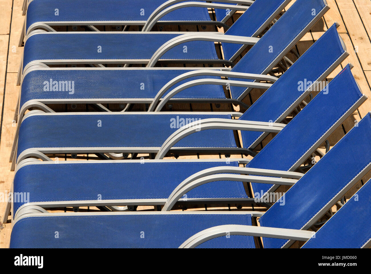 Liegestühle am Pool auf einem Kreuzfahrtschiff aufgereiht Stockfoto