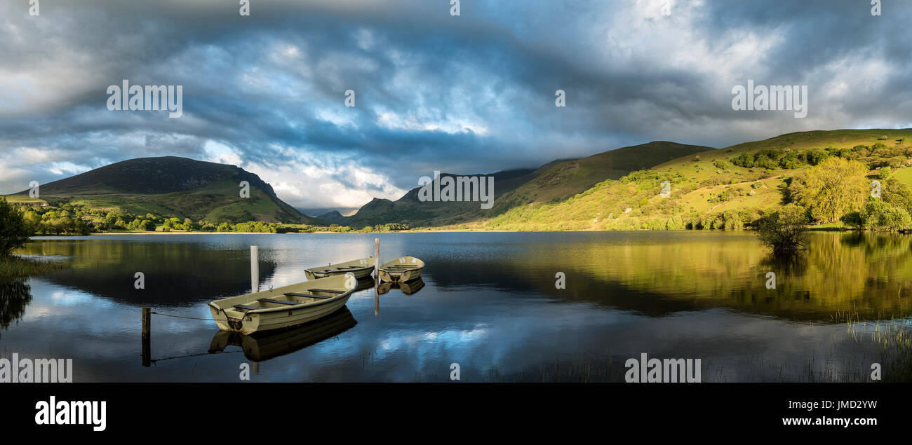 Wunderschönes Panorama Seenlandschaft mit Rowing boats im Vordergrund und Gebirge im Hintergrund Stockfoto