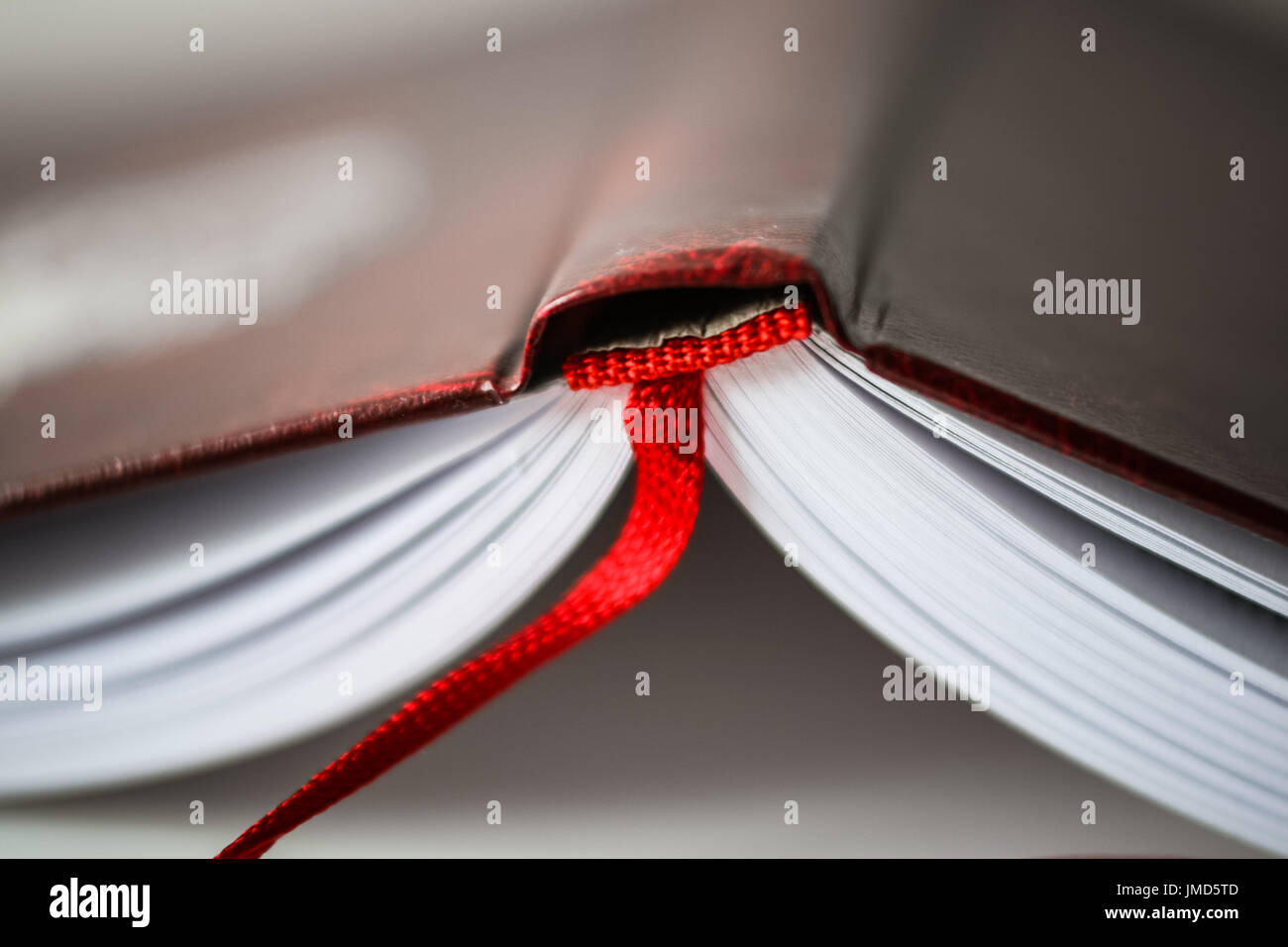 Eine schöne Nahaufnahme eines Buches in dunkle rote Abdeckung und mit roten Lesezeichen. Geringe Schärfentiefe Stockfoto