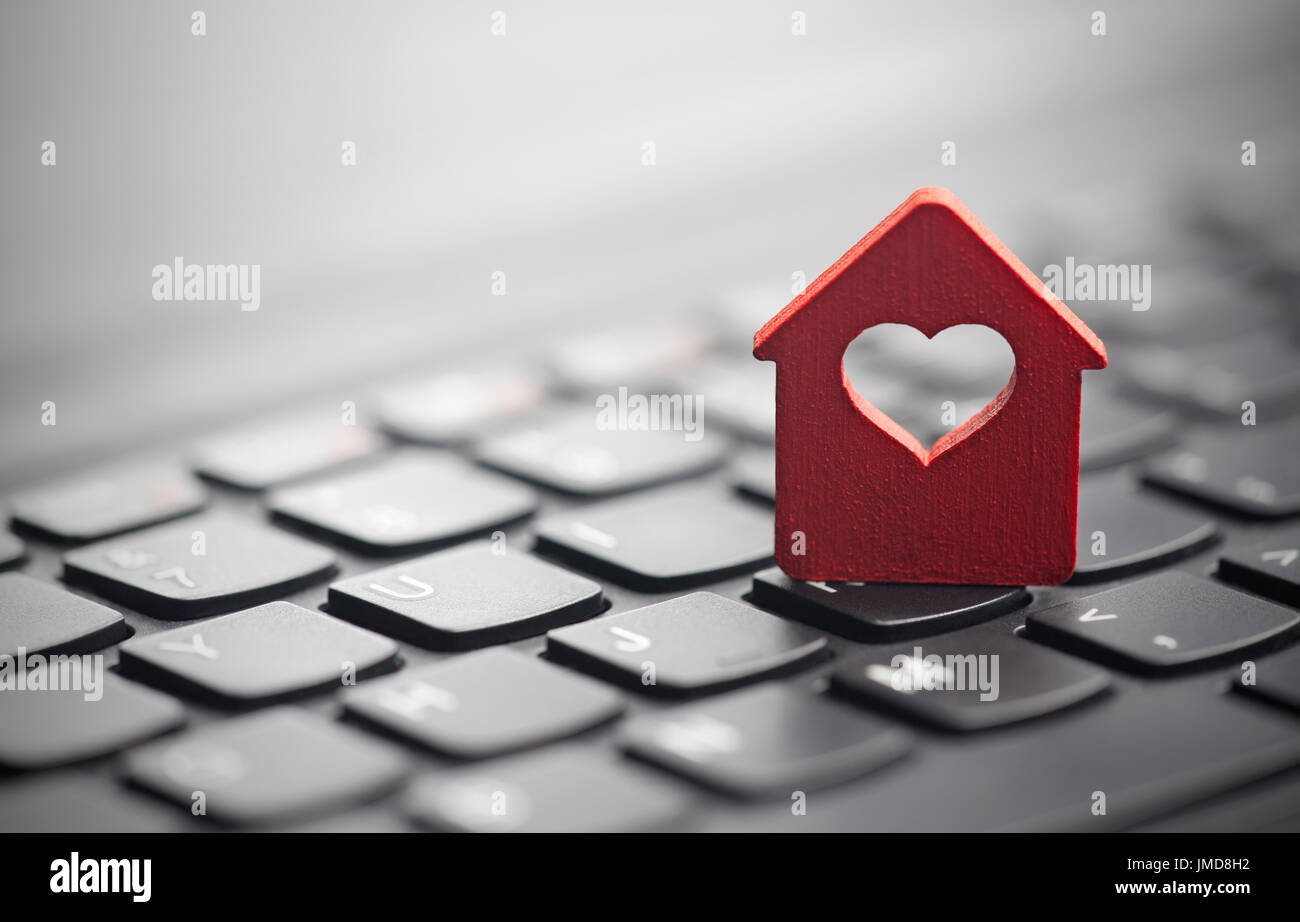 Roten Häuschen mit Herz über Laptop-Tastatur Stockfoto