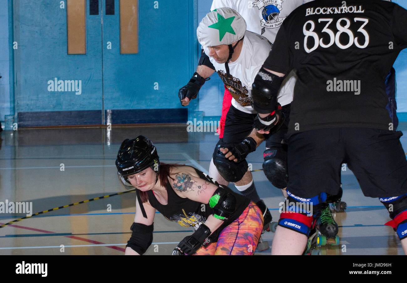 Frauen-Skater auf dem Boden während einer gemischten Roller Derby bout Stockfoto