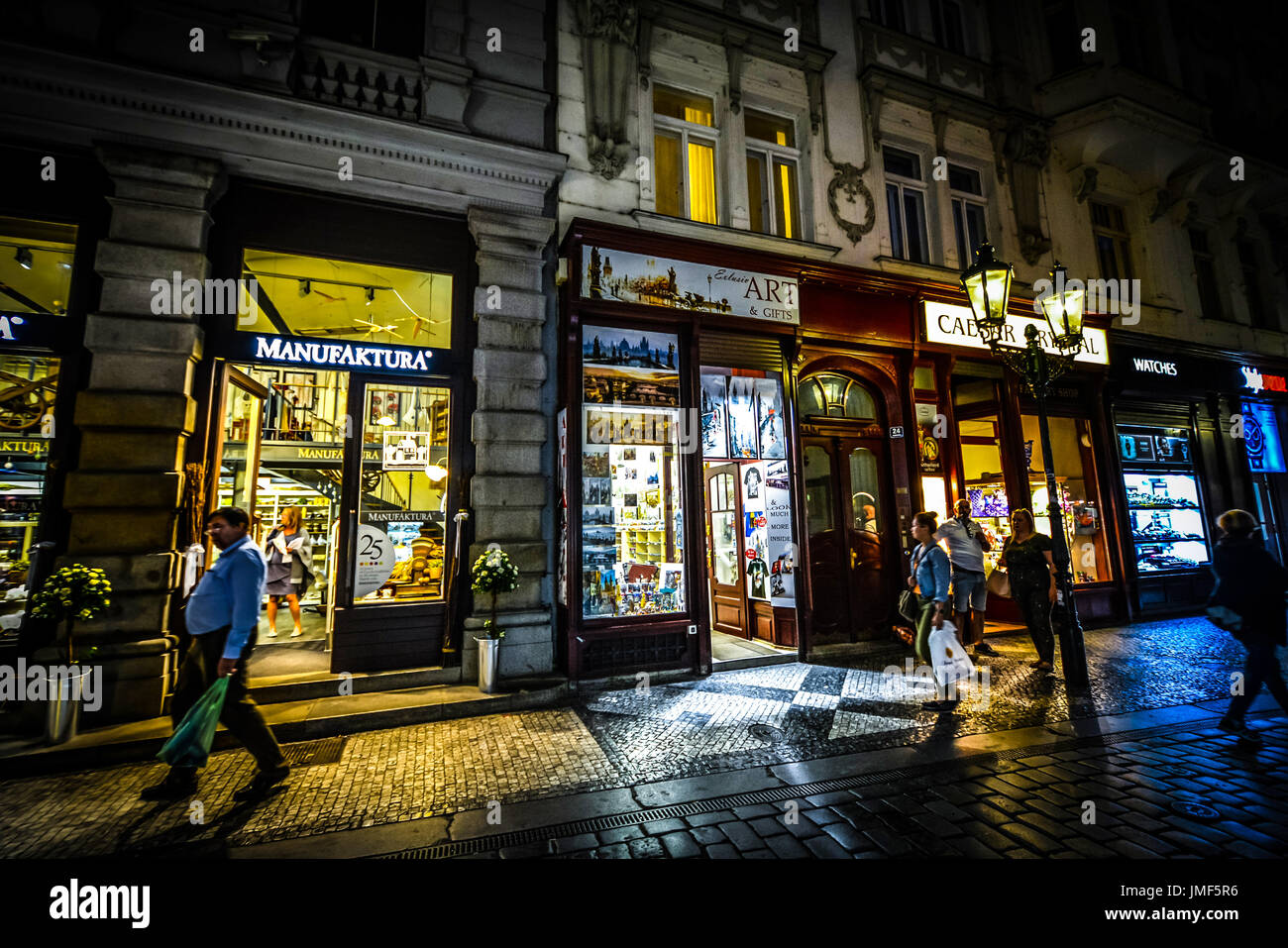 Käufer und Touristen gehen für einige Abend einkaufen in der Praha Bezirk von Prag. Die Geschäfte sind gut beleuchtet, mit stimmungsvoller Beleuchtung Stockfoto