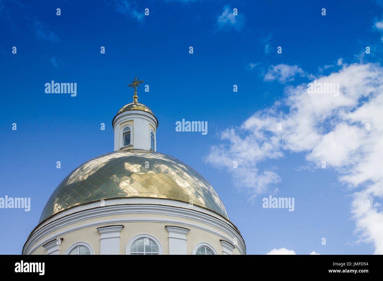 Tempel der orthodoxen Christen mit einer goldenen Kuppel vor blauem Himmel mit weißen Wolken. Stockfoto