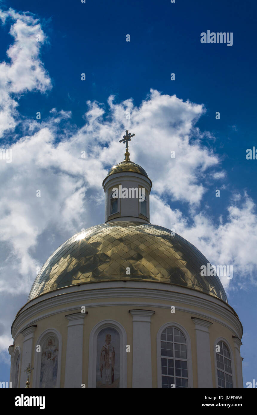 Tempel der orthodoxen Christen mit einer goldenen Kuppel vor blauem Himmel mit weißen Wolken. Stockfoto