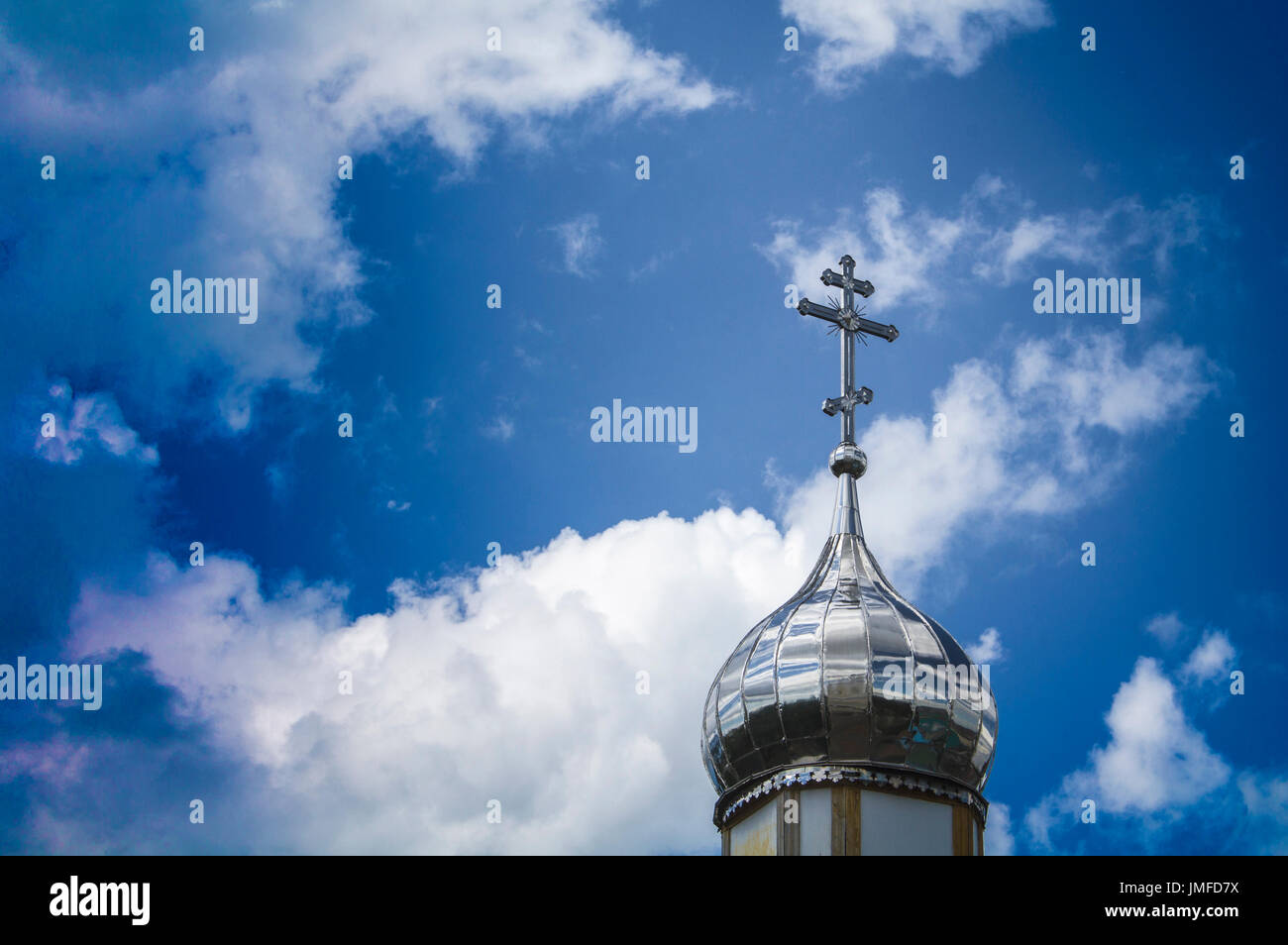 Tempel der orthodoxen Christen mit einer silbernen Kuppel vor blauem Himmel mit weißen Wolken. Stockfoto