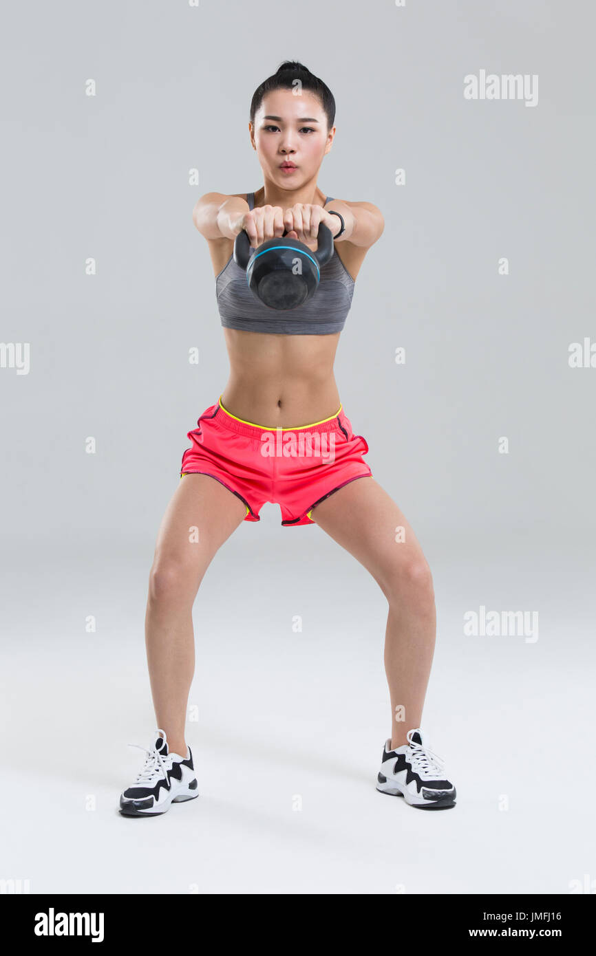 Junge Chinesin mit Kettlebell training Stockfoto