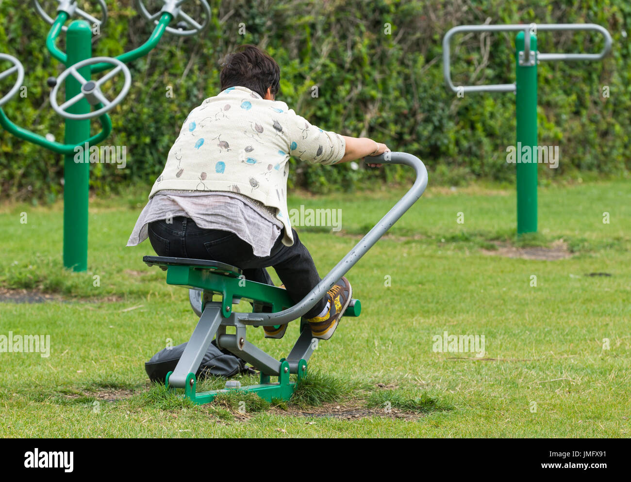 Outdoor-Fitness-Studio. Applying Dame mit Vorrichtung an eine externe Gym in Worthing, West Sussex, England, UK. Stockfoto