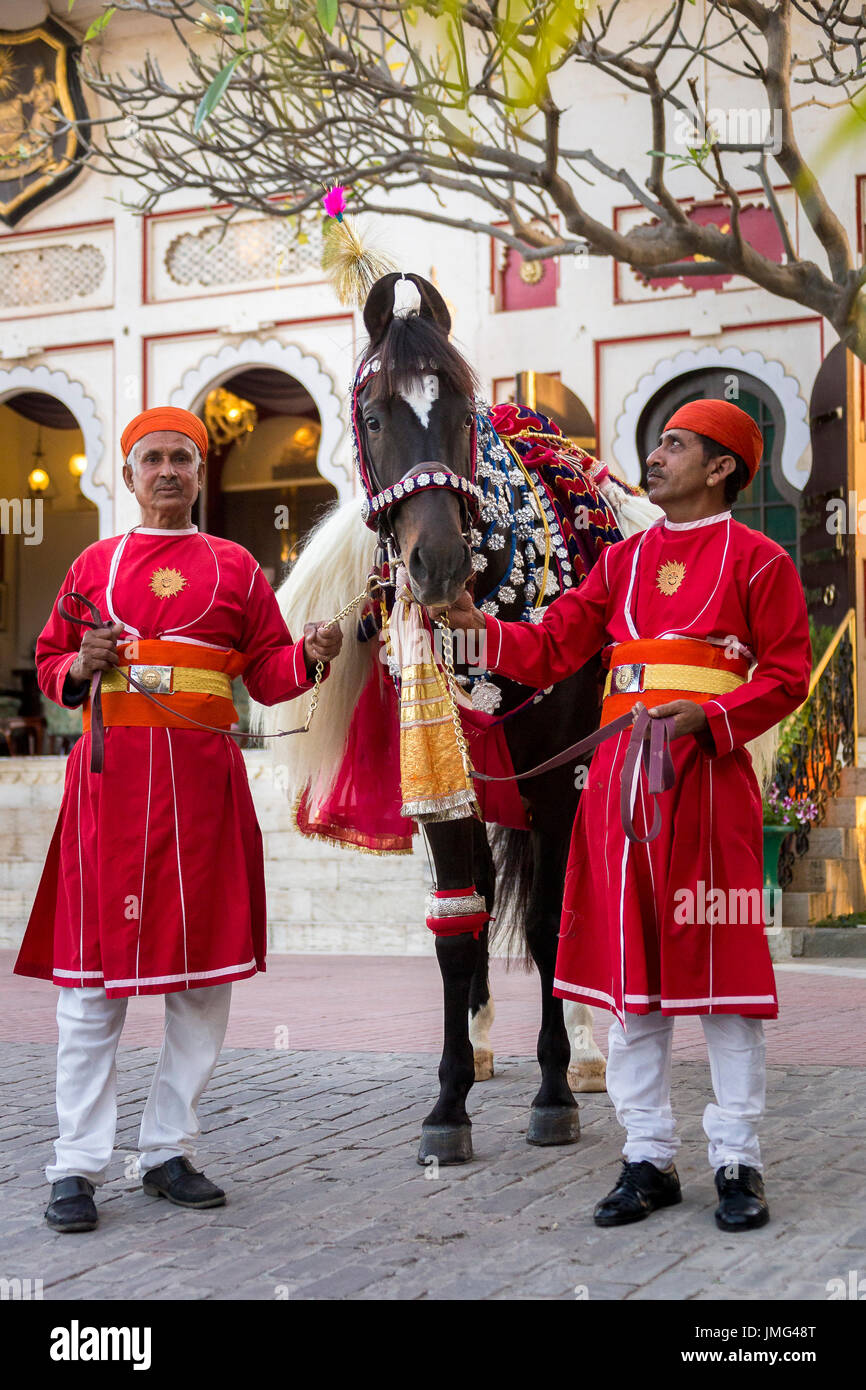 Marwari Pferde mit zwei Pfleger aufwendig dekoriert. Teilnehmer am Holi-Festival im City Palace, Udaipur, Indien Stockfoto
