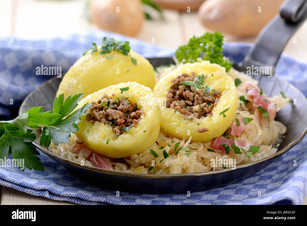 Kartoffelknödel gefüllt mit Hackfleisch, serviert mit Sauerkraut und ...