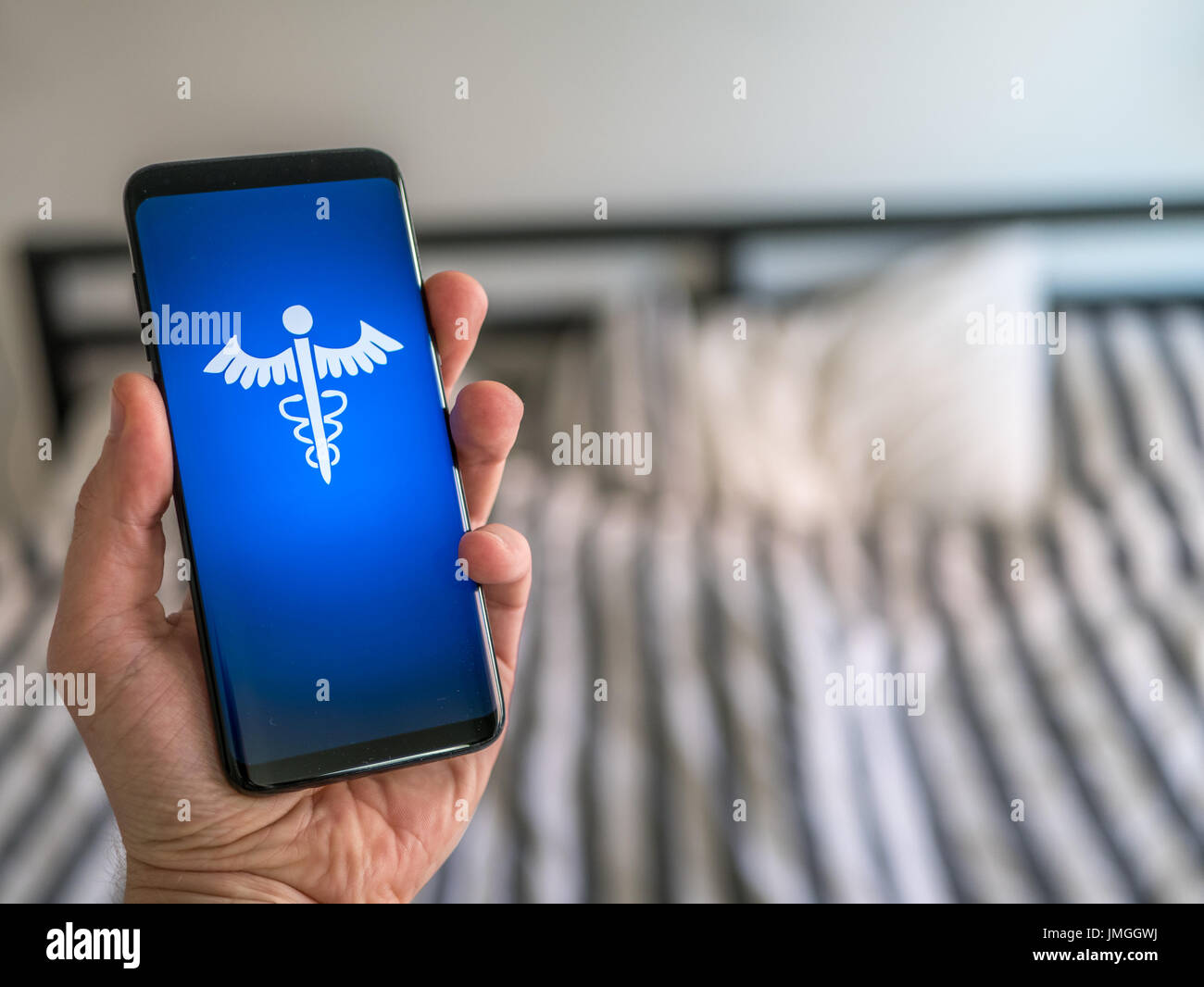 Hand, die eine Smartphone mit Gesundheitswesen ca. Online Arzt zu Hause. Stockfoto