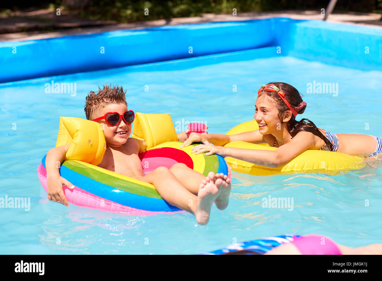 Im Sommer spielen die Kinder in Badeanzügen im Pool. Stockfoto