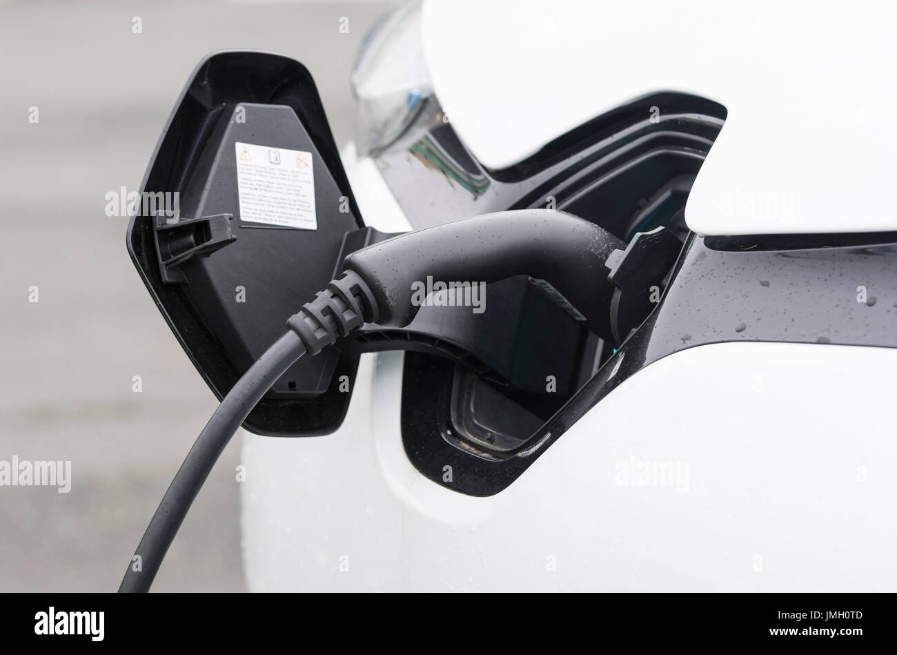 Autobatterie Ladeanschluss mit einem kleinen elektrischen Auto beim Aufladen der Batterien angeschlossen. Grünes Energiekonzept. Stockfoto