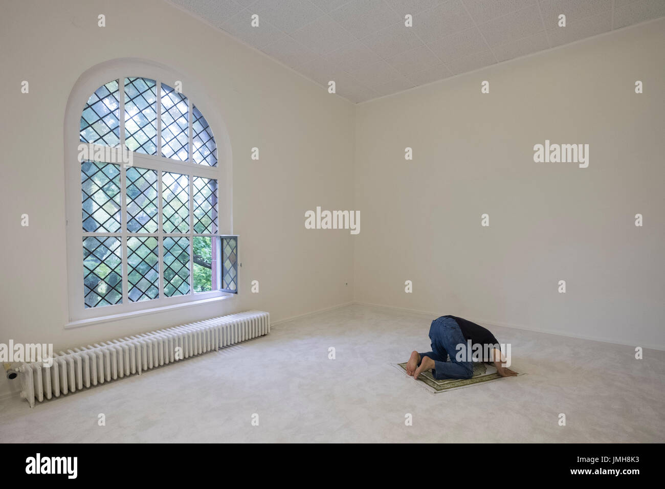 Mann, der betet Moschee Ibn Rushd-Goethe in St.-Johannis-Kirche in Berlin. Gegründet von Seyran Ateş, ist es eine liberale Moschee offen für Männer und Frauen. Stockfoto