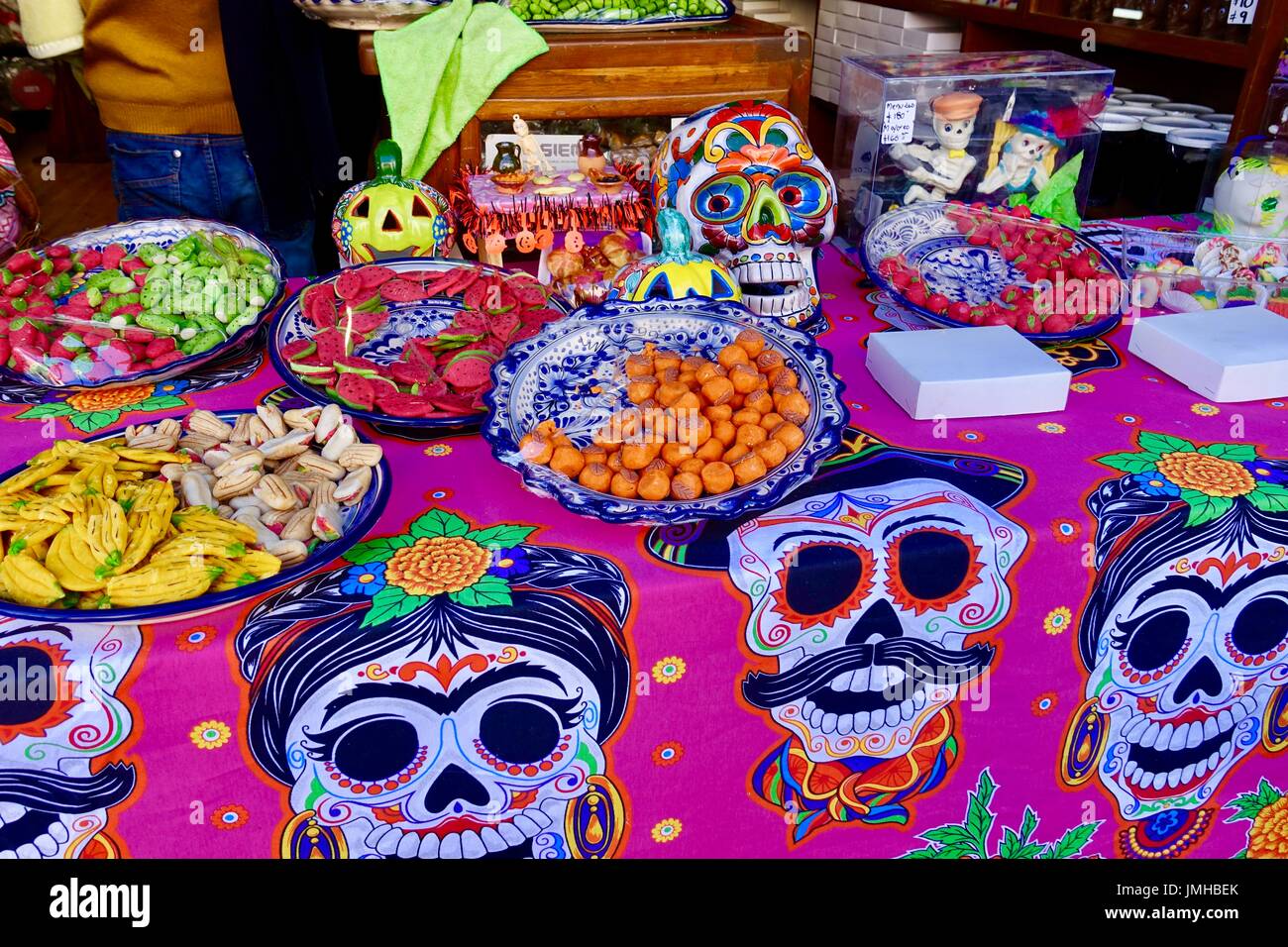 Bunte Leckereien dargelegt auf Muertos, Tag der Toten, unter dem Motto Tischdecke in Puebla, Mexiko Souvenirladen. Stockfoto