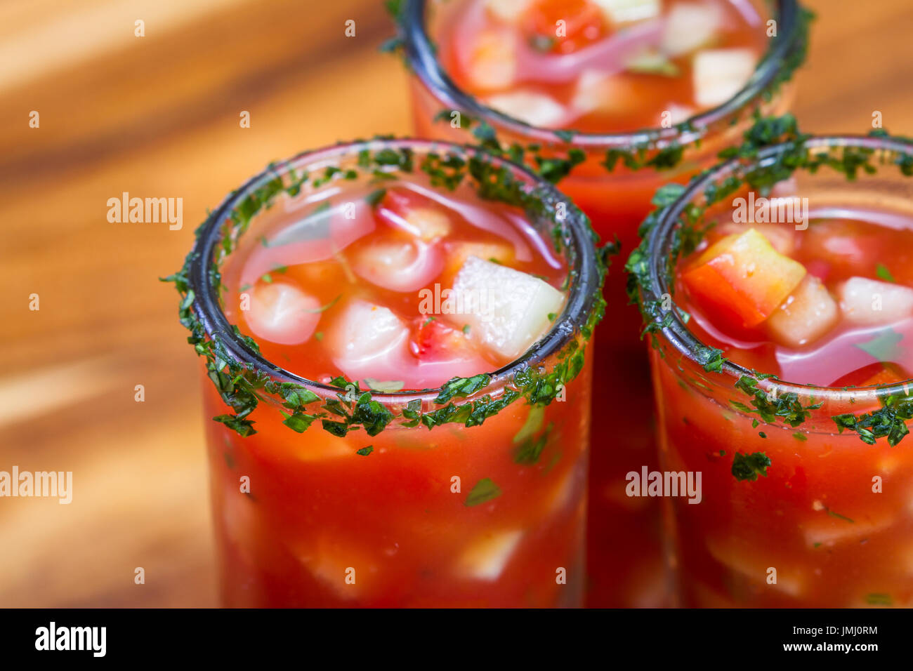 Gazpacho-Sampler in hohe Schnapsgläser mit Koriander Rand als erfrischende Sommer Suppe serviert Stockfoto