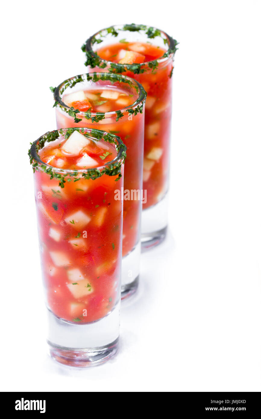 Gazpacho-Sampler serviert in hohe Schnapsgläser mit Koriander Rand isoliert auf weißem Hintergrund Stockfoto