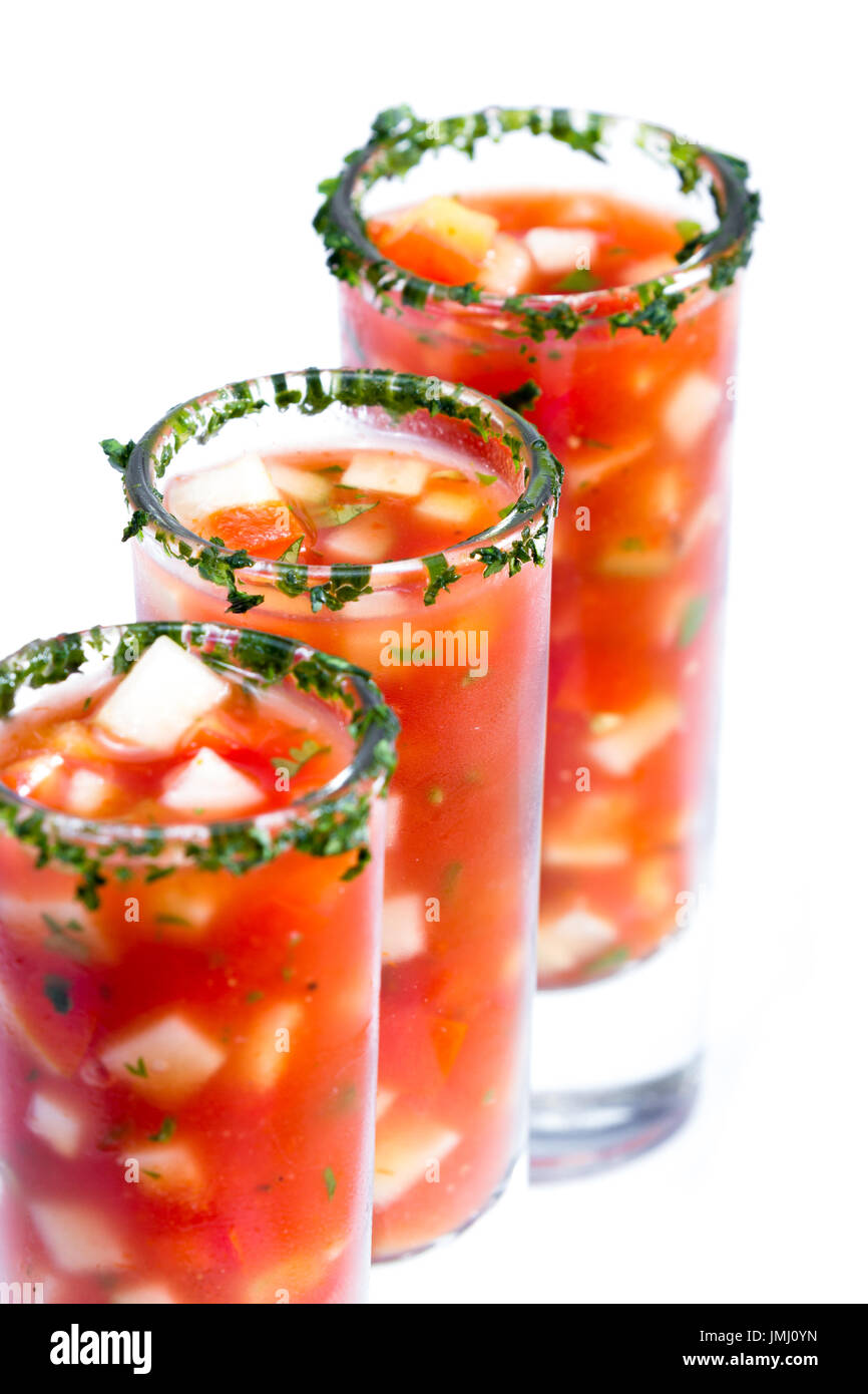 Gazpacho-Sampler serviert in hohe Schnapsgläser mit Koriander Rand isoliert auf weißem Hintergrund Stockfoto
