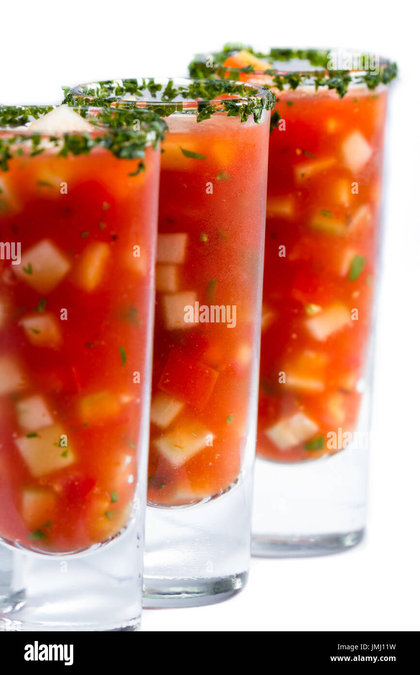 Gazpacho-Sampler serviert in hohe Schnapsgläser mit Koriander Rand isoliert auf weißem Hintergrund Stockfoto
