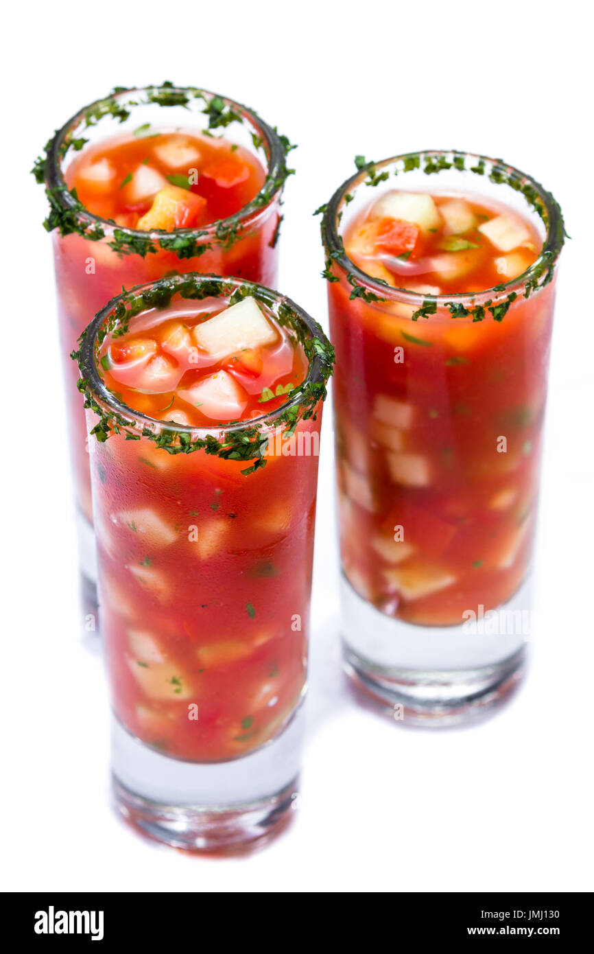 Gazpacho-Sampler serviert in hohe Schnapsgläser mit Koriander Rand isoliert auf weißem Hintergrund Stockfoto