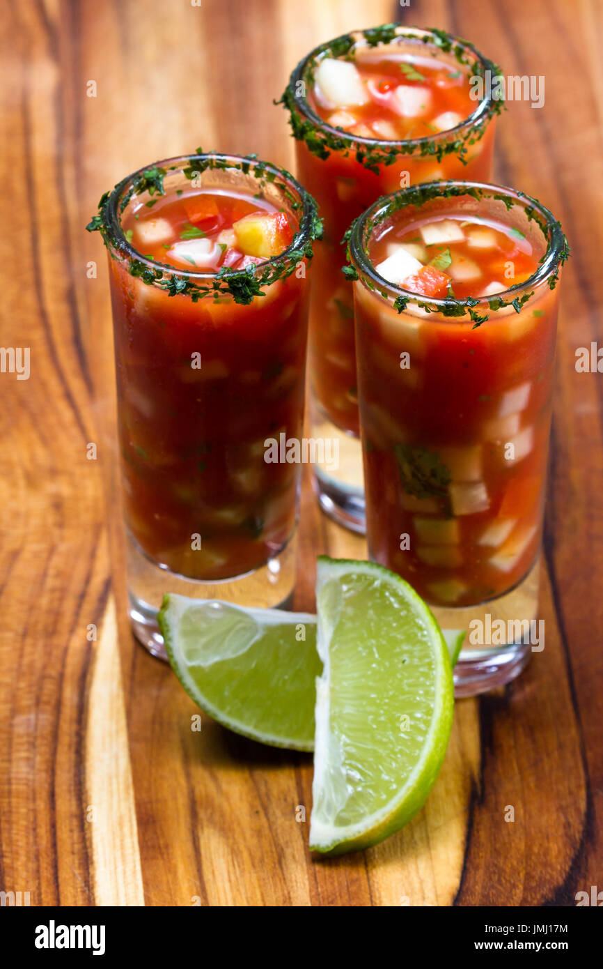 Gazpacho-Sampler in hohe Schnapsgläser mit Koriander Rand als erfrischende Sommer Suppe serviert Stockfoto