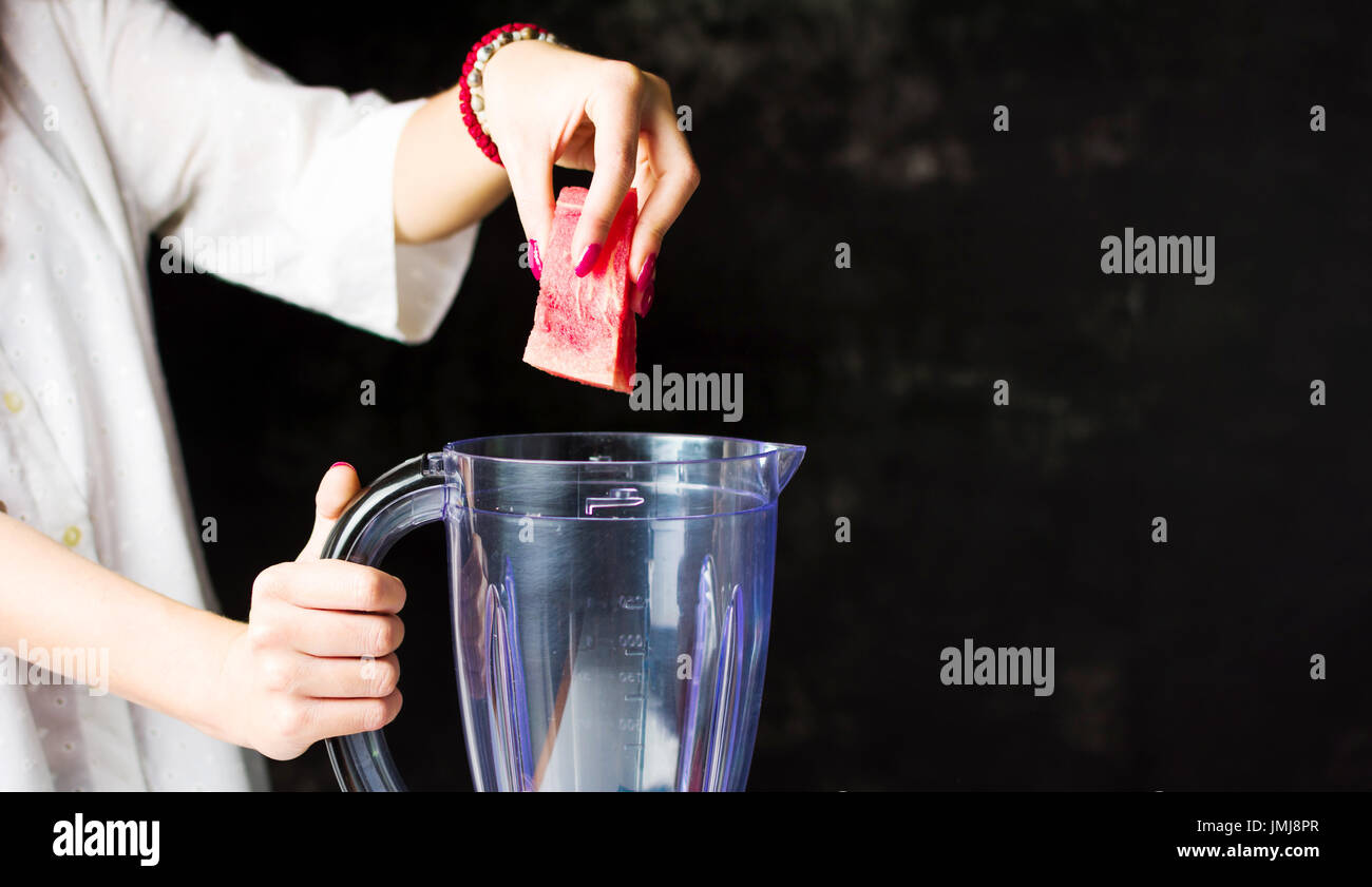 Einfügen von Wassermelone Scheiben in einem Mixer zu einen Smoothie machen weiblich Stockfoto Einfügen von Wassermelone Scheiben in einem Mixer zu einen Smoothie machen weiblich Stockfoto