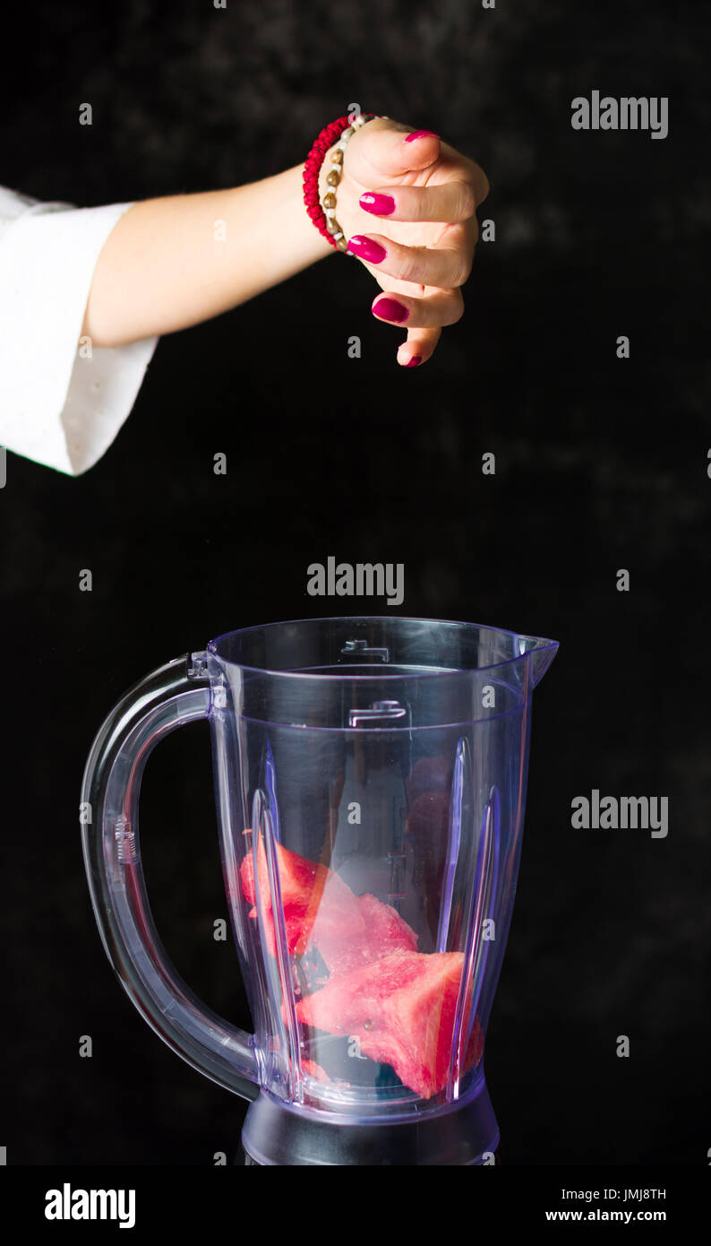 Einfügen von Wassermelone Scheiben in einem Mixer zu einen Smoothie machen weiblich Stockfoto Einfügen von Wassermelone Scheiben in einem Mixer zu einen Smoothie machen weiblich Stockfoto