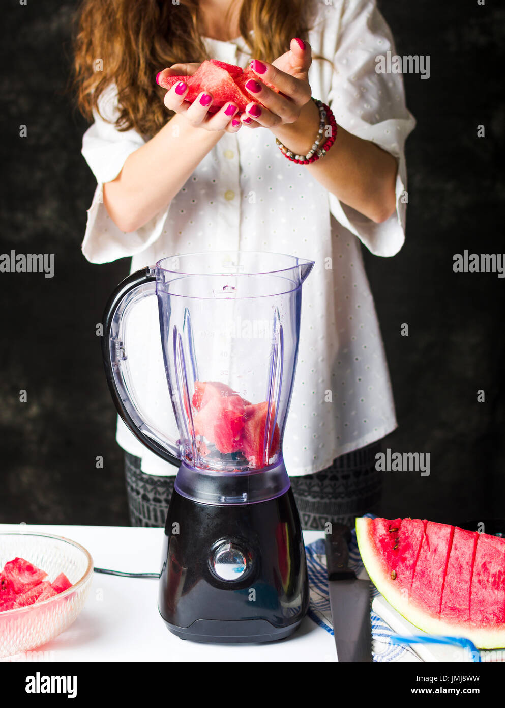 Einfügen von Wassermelone Scheiben in einem Mixer zu einen Smoothie machen weiblich Stockfoto Einfügen von Wassermelone Scheiben in einem Mixer zu einen Smoothie machen weiblich Stockfoto