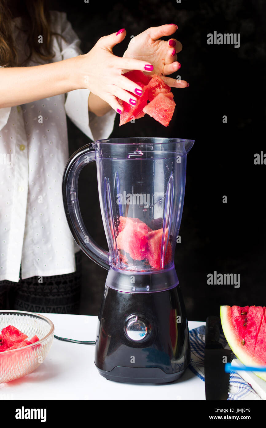 Einfügen von Wassermelone Scheiben in einem Mixer zu einen Smoothie machen weiblich Stockfoto Einfügen von Wassermelone Scheiben in einem Mixer zu einen Smoothie machen weiblich Stockfoto