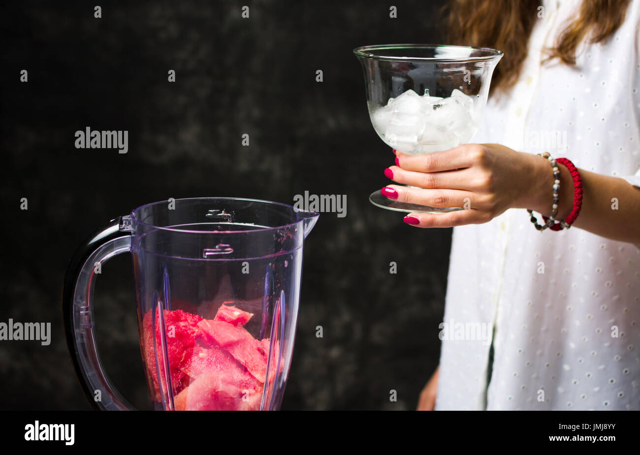 Weiblich, Hinzufügen von Eis in den Mixer für einen Wassermelonen-smoothie Stockfoto Weiblich, Hinzufügen von Eis in den Mixer für einen Wassermelonen-smoothie Stockfoto