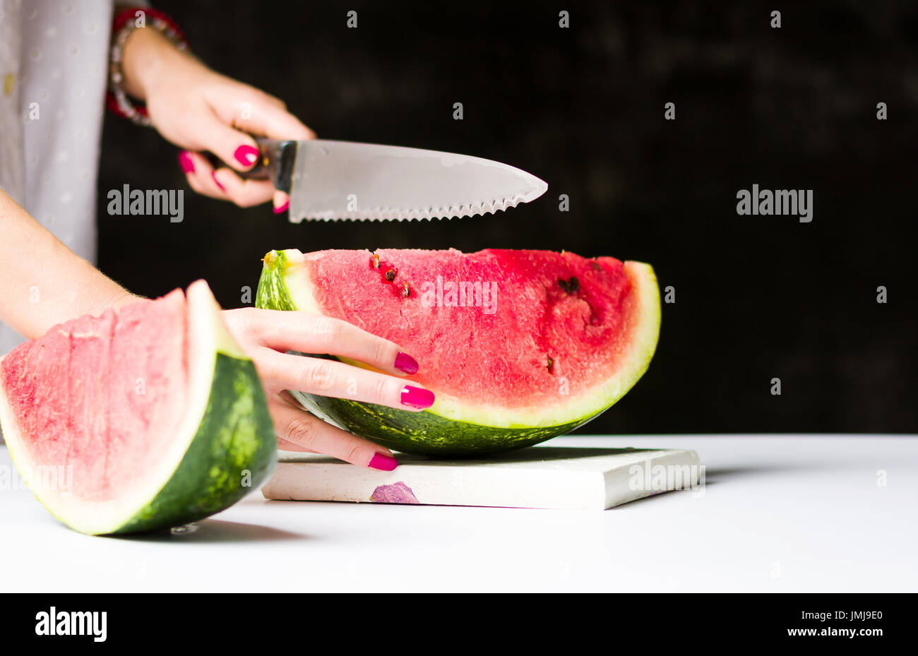 Frau, schneiden Wassermelone auf ein Schneidebrett Stockfoto