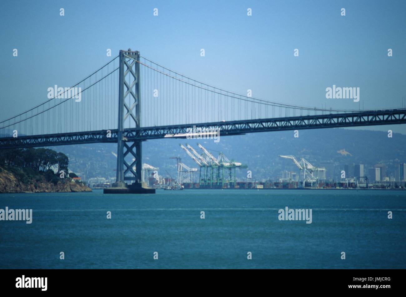 Portalkräne im Hafen von Oakland sind sichtbar unter der Überspannung der Bay Bridge, in der Bucht von San Francisco, San Francisco, Kalifornien, 13. Juni 2017. Stockfoto