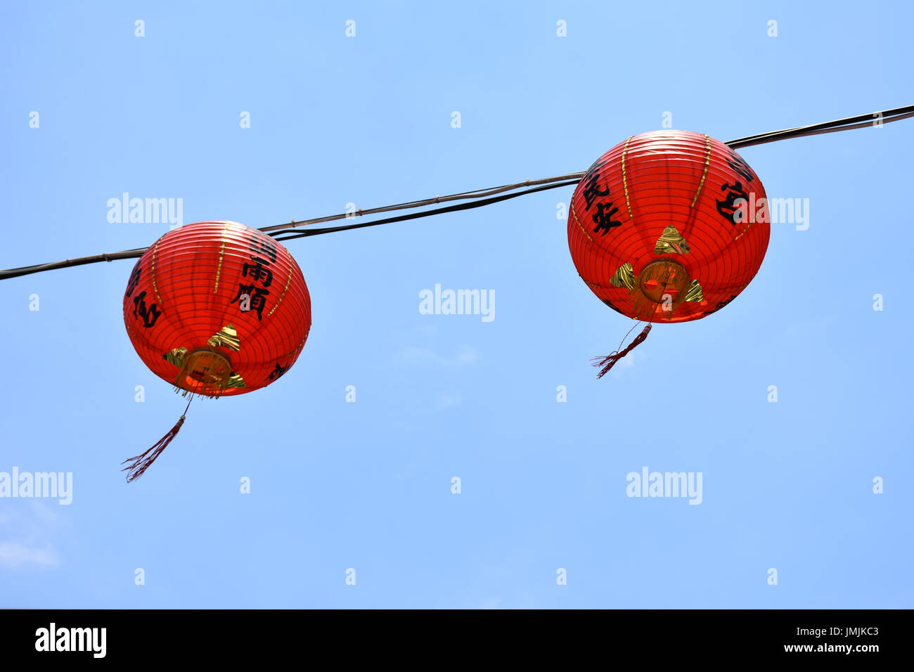 Zwei roten Lampions hängen vor einem blauen Himmel wehen sanft im Wind, Taipei, Taiwan. Stockfoto