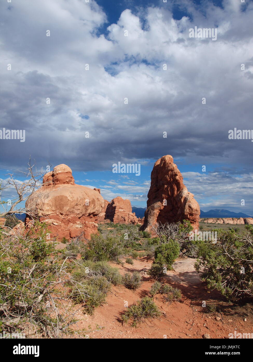 Paar von roten Felsformationen unter Gewitterwolken in High Desert Stockfoto