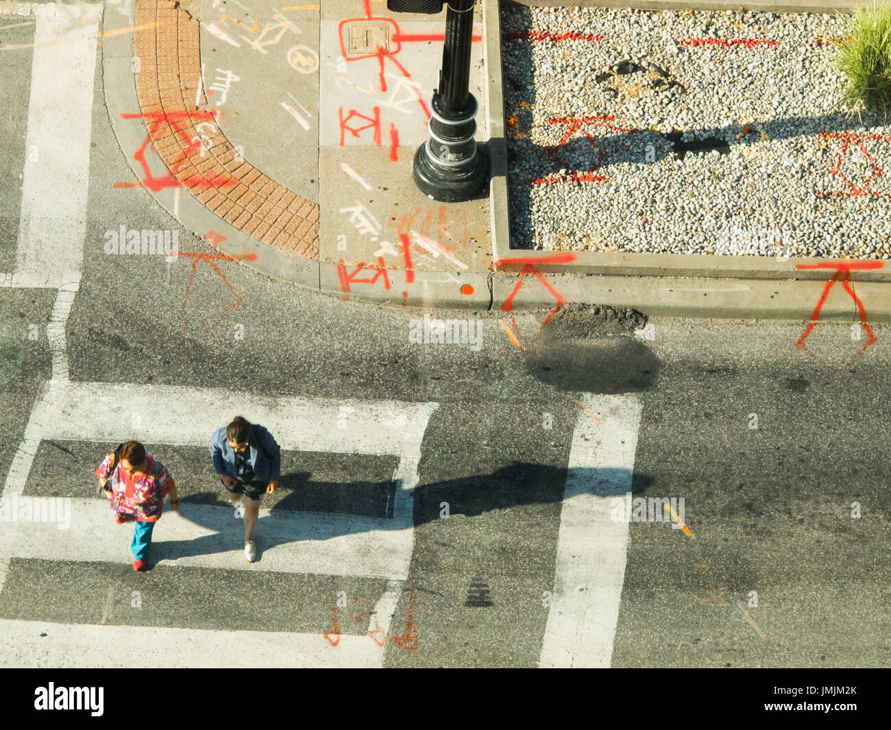 Menschen in städtischen Kreuzung wo Bau Markierungen sehen aus wie Runen gefangen von Oben Stockfoto