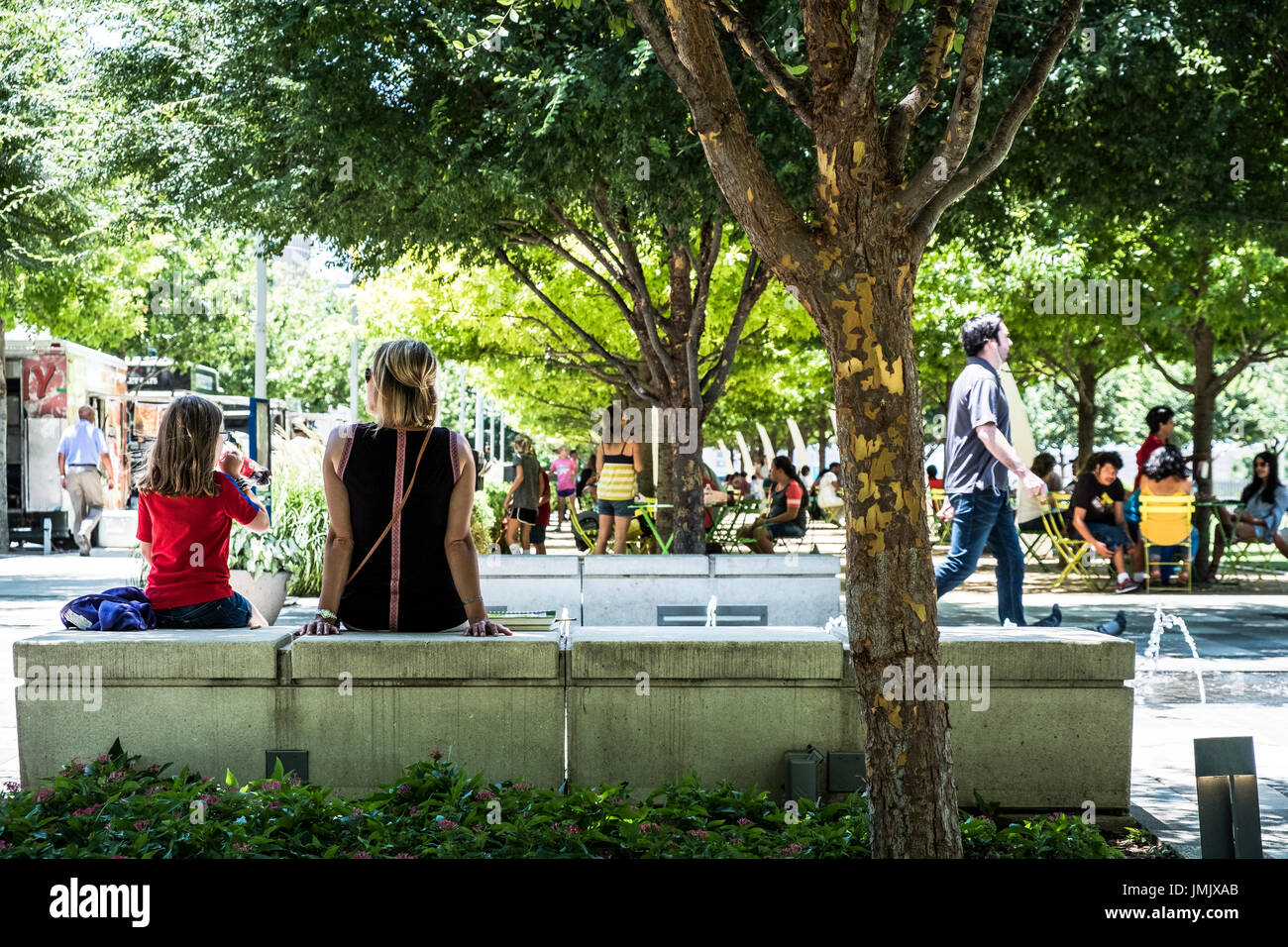 Bewohner zu entkommen die Mitte Tag Hitze im Schatten der Eichen im Klyde Warren Deck Park in der Innenstadt von Dallas Texas Stockfoto